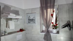 un bagno con doccia con un vaso di rose di La Casa del Sole a Vico Equense Altre 34 foto