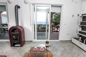 Holiday Home Siesta في دوبرا فودا: غرفة معيشة مع موقد خشبي وطاولة