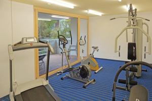 a room with a gym with two tread machines at Switzerland Iseltwald Apartment in Iseltwald