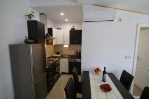 a small kitchen with a table and a refrigerator at Oak House in Zadvarje