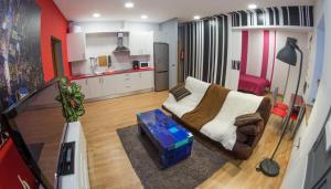 sala de estar con sofá y cocina en Ocho Home Apartamentos, en Zamora