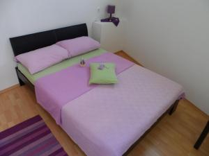 ein Schlafzimmer mit einem lila Bett mit zwei Kissen in der Unterkunft Apartments Dalia House in Hvar