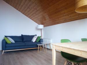a living room with a blue couch and a table at Apartment Sant'Andrea, Brixen - Plose Ski, Hike, Bike, Nature in SantʼAndrea in Monte