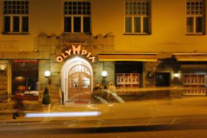 two people walking in front of a store at night at Kesähotelli Aurora in Tampere +15 photos