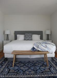 a bedroom with a large bed with a wooden bench at The Sea Breeze Inn in Middletown