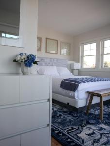 a white bedroom with a bed and a table at The Sea Breeze Inn in Middletown