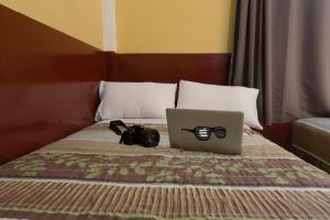 un ordenador portátil y una cámara en una cama con un ordenador portátil en Hotel Ajau en Guatemala