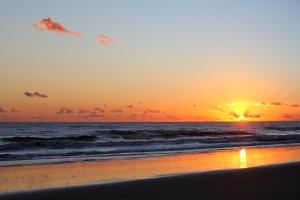 una puesta de sol en una playa con el océano en Barceló Punta Umbría Beach Resort, en Punta Umbría
