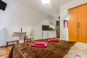 a bedroom with a bed with two red towels on it at Apartmani Mariva in Vodice