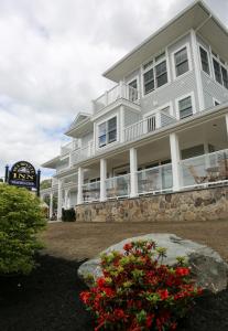 un gran edificio blanco con un gran patio con flores en The Sea Breeze Inn en Middletown