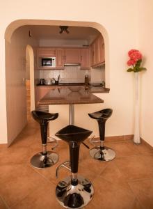 a kitchen with a counter and two bar stools at Casa das Flores in Vale do Lobo