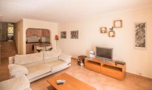 a living room with a couch and a tv at Casa das Flores in Vale do Lobo