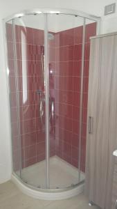 a bathroom with a shower with red tiles at Villa Clale in Montauro +30 photos