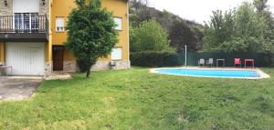 un patio con piscina frente a una casa en Os Arroxos, en Trabadelo