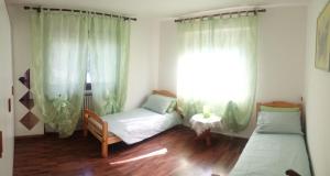 a bedroom with two beds and a window at casa stefy in Saint Vincent