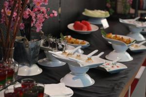 a buffet with plates of food on a table at Bekizaar Hotel Surabaya in Surabaya