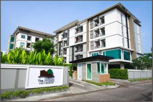 - un grand bâtiment blanc avec un panneau devant dans l'établissement The Prima Residence - SHA Certificate, à Bangkok