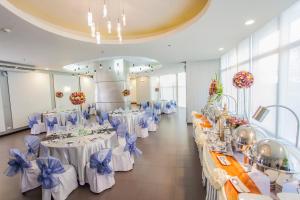a banquet hall with white tables with blue bows at The Exchange Regency Residence Hotel Managed by HII in Manila +76 photos