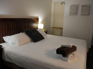 uma cama com duas toalhas e dois bichos de peluche em Bali Studio em Darwin