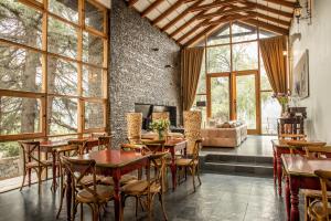 uma sala de jantar com mesas e cadeiras e uma lareira em Casa Arrayán em Santiago