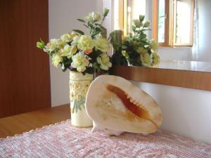 a doughnut sitting on a table next to a vase with flowers at Apartment ANDRIUCI in Cavtat