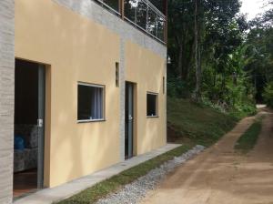 a building with two windows on the side of it at Flats Pedra Riscada in Lumiar