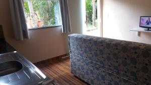 ein Sofa in einem Zimmer mit Fenster in der Unterkunft Flats Pedra Riscada in Lumiar