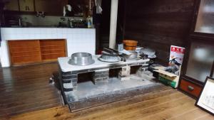 a kitchen with a stove with pots and pans on it at Guesthouse Okagesan in Hongu