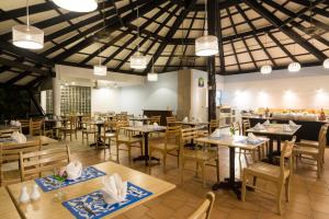un restaurante con mesas de madera, sillas y luces en Patong Lodge Hotel - SHA Extra Plus, en Patong Beach