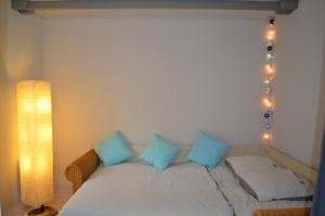 Maison Coetquen في سان مالو: غرفة نوم مع سرير مع الوسائد الزرقاء والأضواء