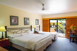 ein Hotelzimmer mit 2 Betten und einem Balkon in der Unterkunft Palm Royale Cairns in Cairns
