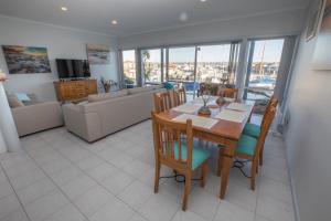 een eetkamer en een woonkamer met een tafel en stoelen bij Marina Reflections in Port Lincoln