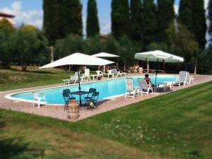 a swimming pool with chairs and tables and umbrellas at Podere La Capacciola in Sinalunga
