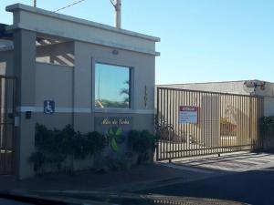 a building with a fence and a sign on it at Condominio Mar de Gales in Macaé
