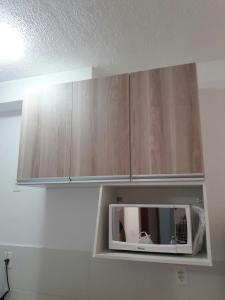 a microwave sitting on top of a kitchen cabinets at Condominio Mar de Gales in Macaé +7 photos