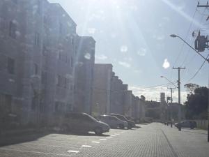 a city street with cars parked on the street at Condominio Mar de Gales in Macaé
