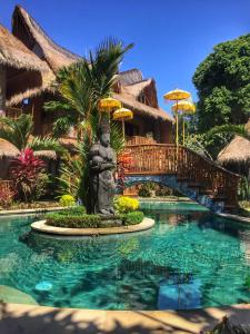 a resort with a statue in the middle of a pool at Bali Bohemia Huts in Ubud