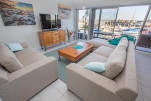 Sala de estar con 2 sofás y TV en Marina Reflections, en Port Lincoln