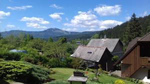 uma vista para uma casa com montanhas ao fundo em Apartmány U Vaců em Železná Ruda