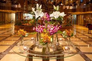 una mesa de cristal con jarrones de flores. en Capitol Hotel Jumeirah Dubai, en Dubái