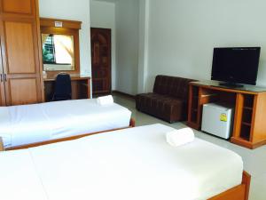 a room with two beds and a couch and a television at Panchan Place in Ubon Ratchathani