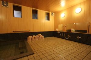 a bathroom with a shower and a sink and a mirror at Kawahiro in Nozawa Onsen