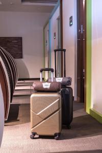 two pieces of luggage sitting in a hallway at sleep 'n fly Sleep Lounge, A-Gates Terminal 3 - TRANSIT ONLY in Dubai