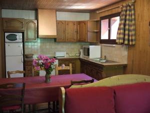 une cuisine avec une table et un vase de fleurs. dans l'établissement Chalet la Ravine, à Valmorel