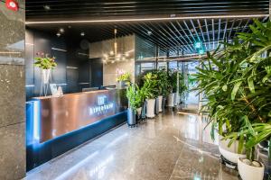 a lobby with potted plants and a reception desk at Rivertain Hotel in Daegu