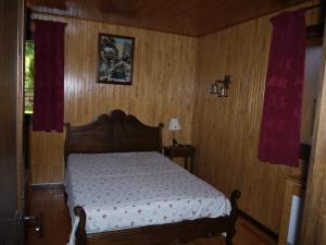- une chambre avec un lit dans une pièce dotée de murs en bois dans l'établissement Chalet la Ravine, à Valmorel