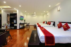 a hotel room with two beds and a television at Little Town Villa in Hoi An +39 photos
