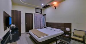 a bedroom with a bed and a television in it at Hotel Saket Heritage in Raigarh