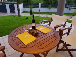 a wooden table with a bottle of wine and two glasses at Dimitris Villa in Aigio