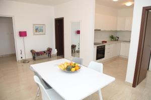 a kitchen with a white table with a bowl of fruit on it at Apartments Mare in Gradac
